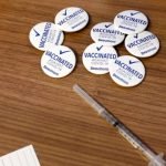 Pins for Beaumont Health Care workers after receiving their first dose of the Pfizer/BioNTech COVID-19 vaccine are seen next to a syringe at their service center in Southfield, Mich., on Dec. 15, 2020. (Jeff Kowalsky/AFP via Getty Images)