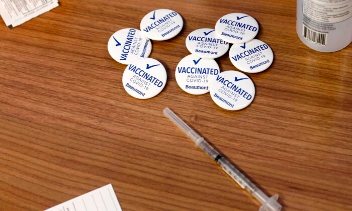 Pins for Beaumont Health Care workers after receiving their first dose of the Pfizer/BioNTech COVID-19 vaccine are seen next to a syringe at their service center in Southfield, Mich., on Dec. 15, 2020. (Jeff Kowalsky/AFP via Getty Images)