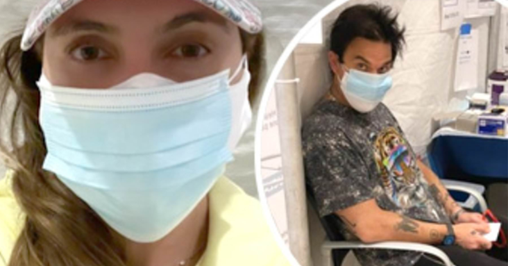 Ayda Field and wild-haired husband Robbie Williams document having their first dose of the coronavirus vaccine in LA